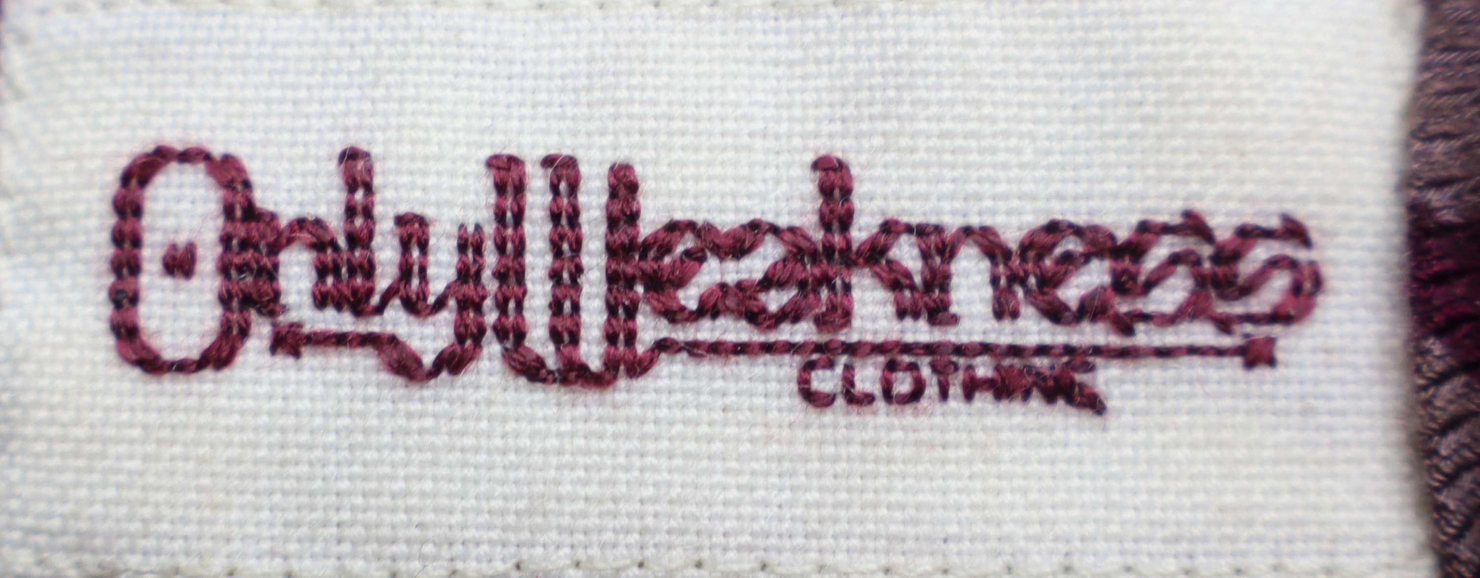 our hand-stitched tag, reading 'only weakness'